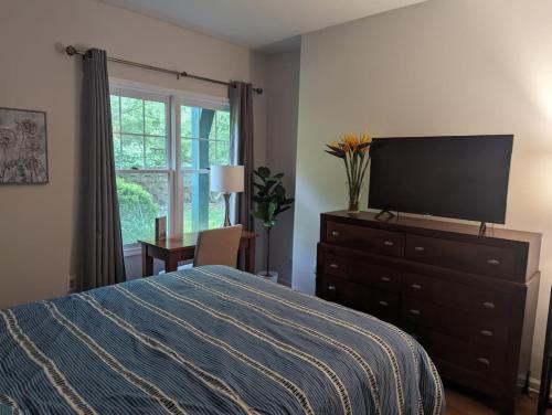 a bedroom with a bed and a dresser with a television at Country Chic New 2 Bed 2 Bath in Vernon Township