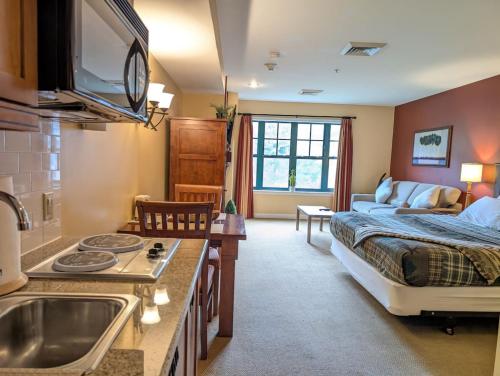 a bedroom with a bed and a kitchen with a sink at Slope side cozy Studio in Vernon Township