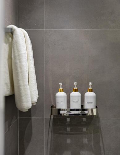 a bathroom with three soap bottles on a glass table at DEX Apartment Korca in Korçë
