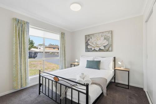 a bedroom with a bed and a large window at Tranquil Escape by the Water in Triabunna