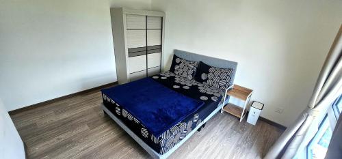 a bedroom with a bed with a blue comforter at Master Room with Private Bath at Kajang in Kajang