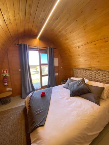 a large bed in a room with a wooden ceiling at Triarca Vinum House in Sabrosa