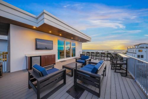 a balcony with chairs and tables and a television at Top Deck Estate in Siesta Key