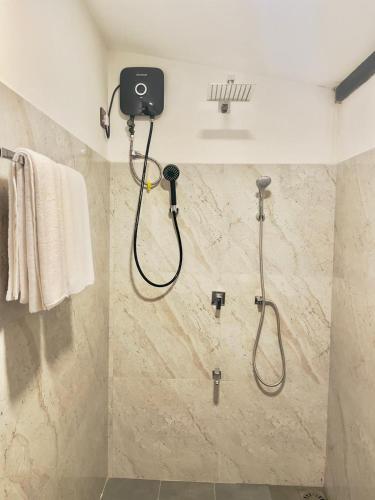 a bathroom with a shower with a shower head at Rainforest Mountain Escape - Lankagama in Deniyaya