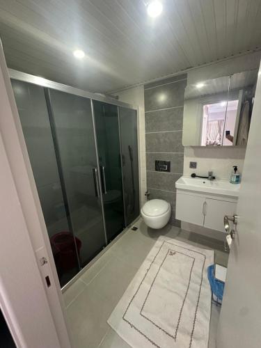 a bathroom with a glass shower and a toilet at Konyaaltı gürsu denize sıfır sahilde full eşyalı lüks daire in Antalya