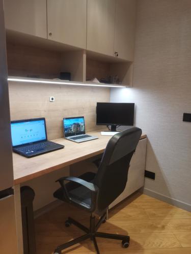 an office with a desk with two laptops and a chair at Centro Residence in Kluczbork
