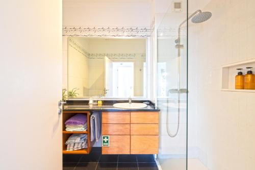 a bathroom with a sink and a shower at Pátio da Achada View Apartment in Funchal