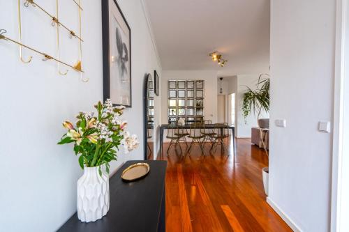 a living room with a vase of flowers on a table at Pátio da Achada View Apartment in Funchal
