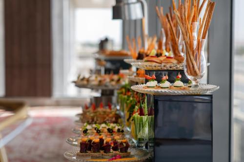 une présentation de desserts et de pâtisseries sur des assiettes disposées sur une table dans l'établissement Waves Hotel, à Umm Lajj