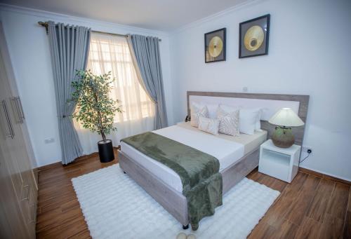 a bedroom with a bed and a large window at The Prestige Hub Residences in Eldoret