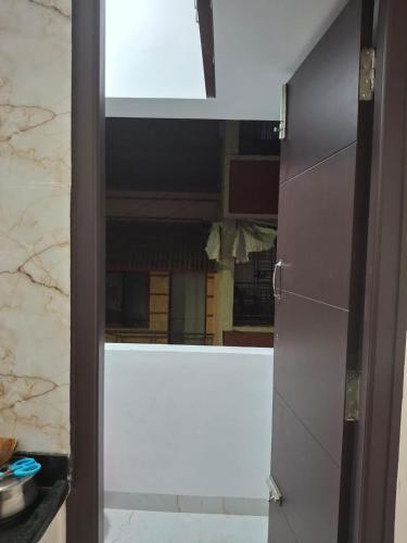 a door to a kitchen with a view of a mirror at SUMATHY GIRLS HOSTEl in Chennai