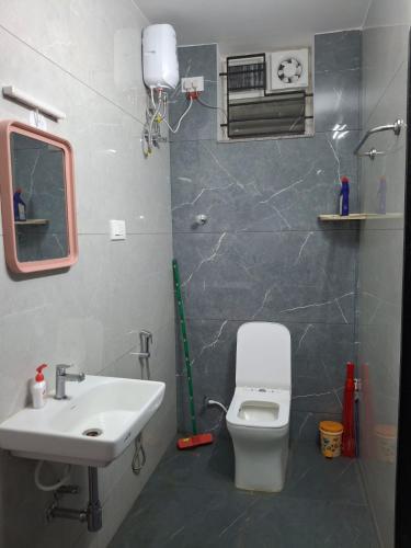 a bathroom with a white toilet and a sink at SUMATHY GIRLS HOSTEl in Chennai