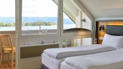 a bedroom with two beds and a large window at DaSalvatore in Wasserburg