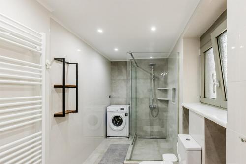 a bathroom with a shower and a washing machine at Angie's Central Apartment in Pappadhiánika