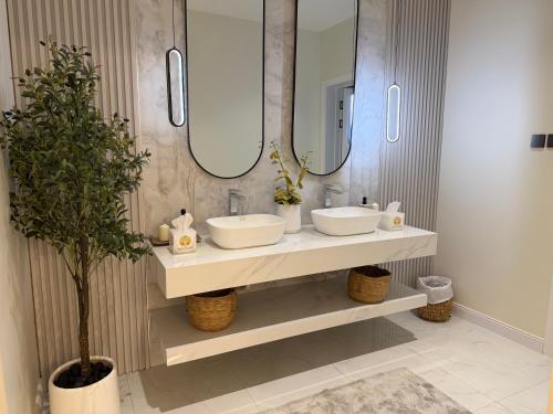 a bathroom with two sinks and two mirrors at Quiet House villa in Hatta