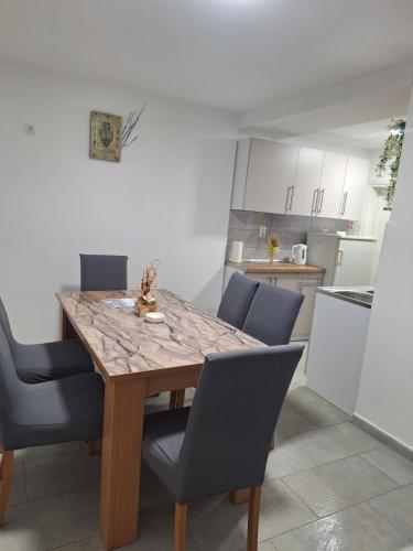 a kitchen with a wooden table and chairs at King Rooms in Novi Kneževac