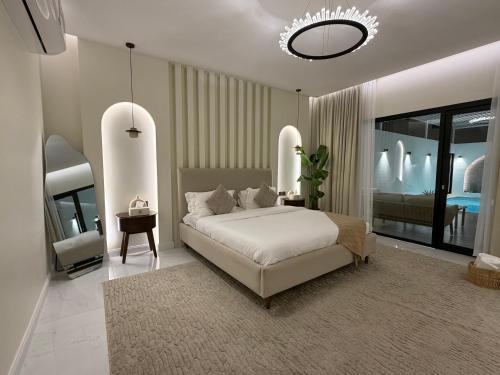 a bedroom with a bed and a chandelier at Quiet House villa in Hatta