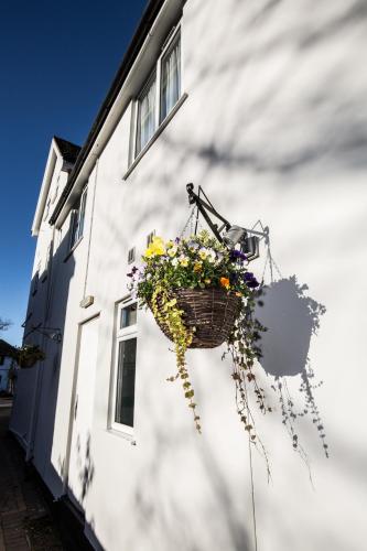 a basket of flowers hanging on the side of a building at The Peacock Townhouse Hotel Kenilworth - Warwick in Kenilworth