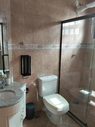 a bathroom with a toilet and a sink and a shower at Casa da Dinda 103 in Rio das Ostras