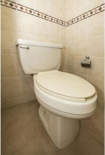 a bathroom with a white toilet in a room at OYO Hotel La Glorieta, Huichapan in Huichapan