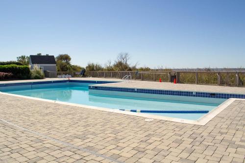 a swimming pool with blue water in a yard at Sparrow's Rest - Duck, Sanderling, 350 Yards to the Beach, Community Pool, YR Flex Stays in Duck