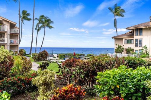 a view of a resort with palm trees and the ocean at Sea Village 2106 in Kailua-Kona