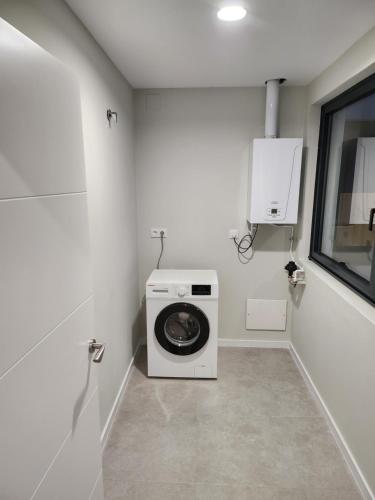 a laundry room with a washing machine and a window at CREDENCIAL Bulevar in Sarria