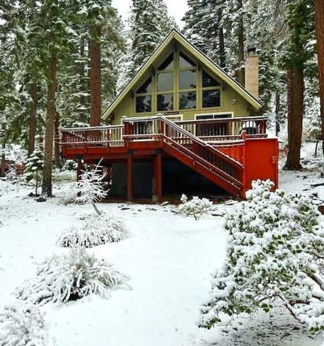 a house with a deck in the snow at Honey Bear Cabin in Carnelian Bay