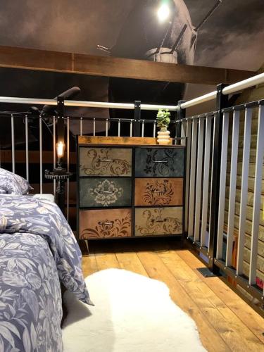 a bedroom with a bed and a wooden floor at Le Garage in Lamotte-Beuvron