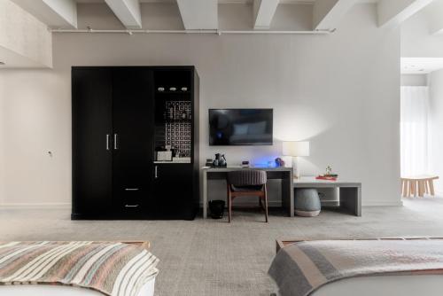 a bedroom with a bed and a desk with a television at Stanton House El Paso in El Paso