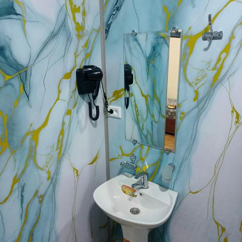 a bathroom with a sink and a mirror at Bro Hostel Angor in Termiz