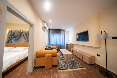 a hotel room with a bed and a couch and a tv at B Suites Boutique Hotel in Amman