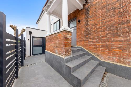 a brick house with stairs on the side of it at Stylish Studio Apt By Stay Smart Short Lets & Serviced Accommodation Golders Green With Free WiFi in London