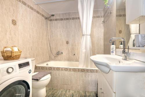 a bathroom with a washing machine and a sink at Casa Di Aspa-Serene Escape with Pool near town in Rethymno