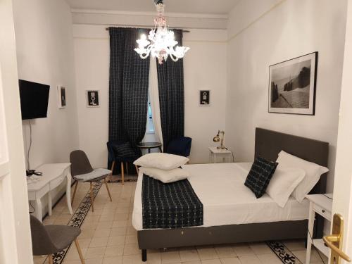 a bedroom with a bed and a chandelier at Short Lets Grandi Stazioni in Bari