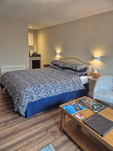 a bedroom with a large bed and a table at taigh beag in Fort William