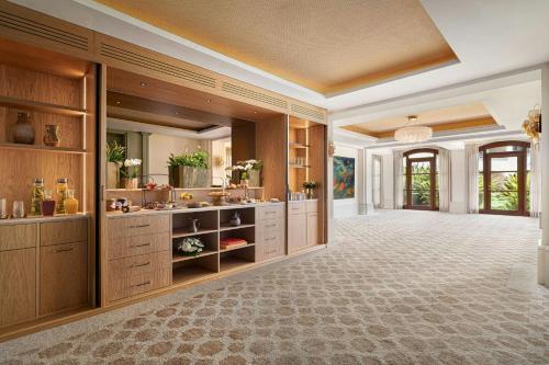 a large bathroom with two sinks and wooden cabinets at The St. Regis Mardavall Mallorca Resort in Portals Nous