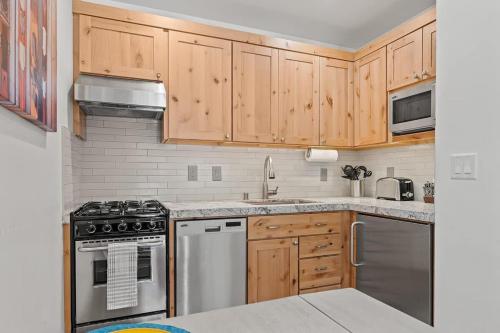 a kitchen with wooden cabinets and stainless steel appliances at Bearfoot Bungalow in Tahoe Vista