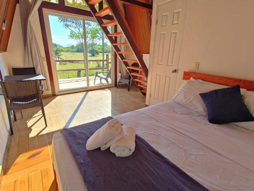 a room with a bed with a towel on it at Cabañas Martina Surf Playa Guanico in Pedregal
