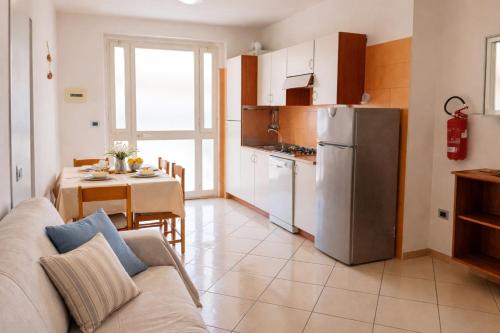 a living room with a couch and a kitchen with a table at Kai beach in Villa Rosa