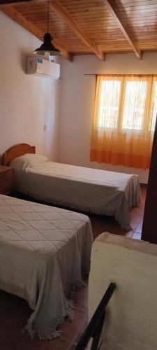 a bedroom with two beds and two windows at El Legado in San Pedro