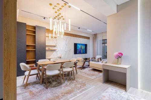 a dining room and living room with a table and chairs at Luxury 98m2, City Boulevard View, Fountain View, Tashkent City in Tashkent