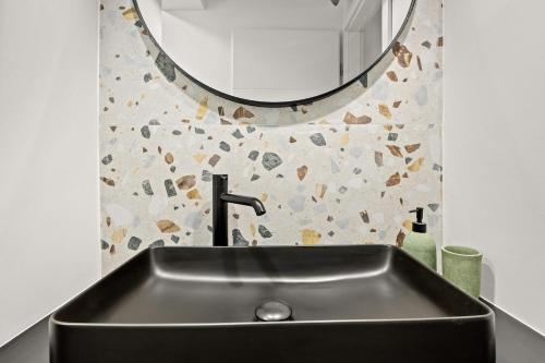 a black sink in a bathroom with a mirror at Stillar Apartment near sea in Pula