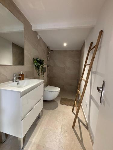a bathroom with a white sink and a toilet at Mazets sous le pin in Le Rouret