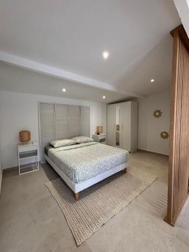a bedroom with a large bed with a white headboard at Mazets sous le pin in Le Rouret