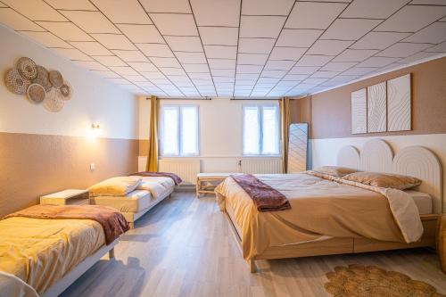 a room with two beds and a ceiling at SBredele - Maison de ville cosy - hypercentre in Sélestat