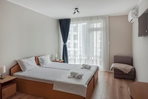 a bedroom with a large bed with towels on it at Solea Family Hotel & Restaurant l Free Parking in Ravda