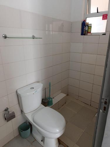 a small bathroom with a toilet and a window at HM Royal Homes in Nairobi