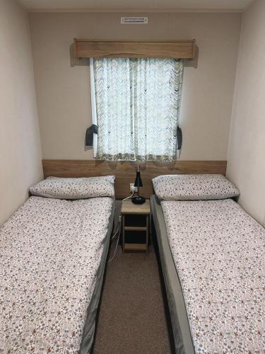 two beds in a small room with a window at St Nicolas in Girvan
