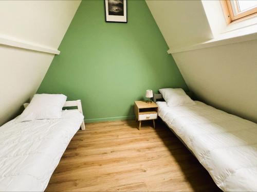two beds in a room with green walls at Villa Margil in Le Tréport